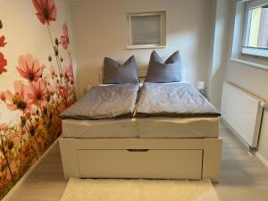 ein Bett mit zwei Kissen darauf in einem Schlafzimmer in der Unterkunft Ferienwohnung im Schwedenhaus in Großpostwitz