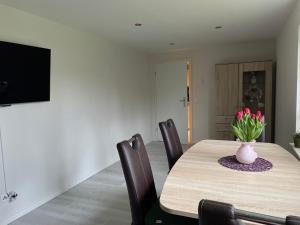 een eettafel met een vaas met bloemen erop bij Ferienwohnung im Schwedenhaus in Großpostwitz