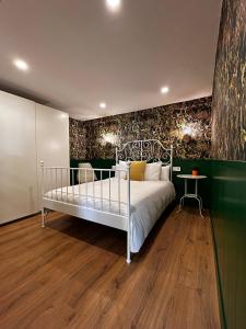 1 dormitorio con cama blanca y pared verde en Apartamento Home Santo, en Santiago de Compostela