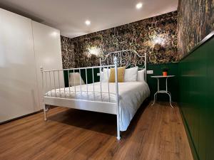 1 dormitorio con cama blanca y pared verde en Apartamento Home Santo, en Santiago de Compostela