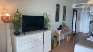 Couleur Caraïbes- 2 Appartements Communicants Vue Mer Pierre&Vacances في سانت لوسي: غرفة معيشة مع تلفزيون بشاشة مسطحة على خزانة بيضاء