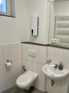Baño blanco con aseo y lavamanos en Diamant Wohnung im Zentrum von Mönchengladbach, en Mönchengladbach