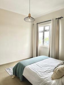 a bedroom with a bed and a window at Pebble Bay Garden View F3 in Grand Baie