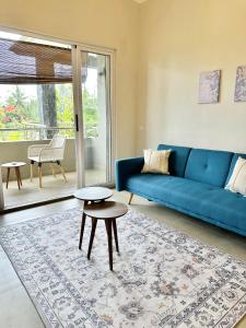 a living room with a blue couch and a table at Pebble Bay Garden View F3 in Grand Baie