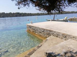 a boat on the water next to a dock at Kuća za odmor Zdravka in Blato