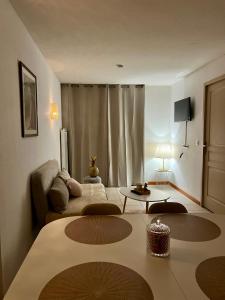 ein Wohnzimmer mit einem Sofa und einem Tisch in der Unterkunft Chez Suzette-Résidence-Piscine-Sauna in Levernois