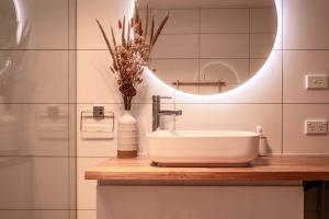 uma casa de banho com um lavatório e um espelho em Hazards Escape - the Top Shack & the Short Stack em Coles Bay