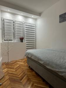 een slaapkamer met een bed en een houten vloer bij House Inn in Pirot