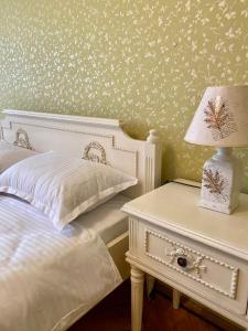a bedroom with a bed and a table with a lamp at Downtown Apartment in Craiova