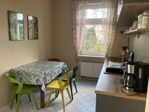 a kitchen with a table and chairs in a kitchen at Ferienwohnung im Leipziger Neuseenland in Böhlen