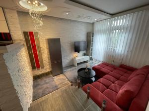 a living room with a red couch and a tv at Lipno Pearl 2 in Lipno nad Vltavou