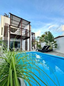 uma villa com piscina em frente a uma casa em LA RESERVE VILLAS BEIJA-FLOR e IPANEMA em Pipa