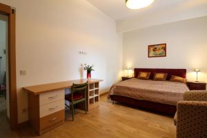 a bedroom with a bed and a desk in front of a bed at Great Amber Apartment in Liepāja
