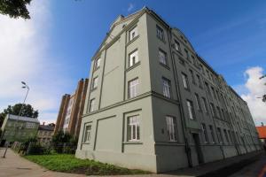 a large gray building on the side of a street at Great Amber Apartment in Liepāja
