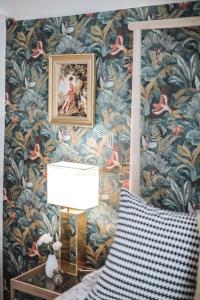 a bedroom with a wall covered in floral wallpaper at Abandonner son quotidien.. C.L.S Deauville in Deauville