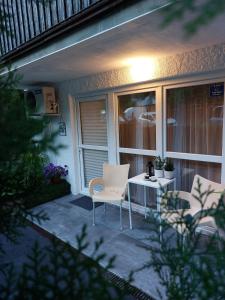 eine Terrasse mit 2 Stühlen und einem Tisch mit Licht in der Unterkunft Bowler Hat Apartment Belgrade in Zvezdara