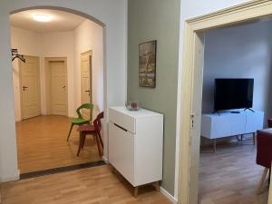 ein Wohnzimmer mit einem weißen Kühlschrank und einem TV in der Unterkunft Ferienwohnung im Leipziger Neuseenland in Böhlen