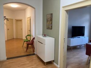 a living room with a white refrigerator and a television at Ferienwohnung im Leipziger Neuseenland in Böhlen