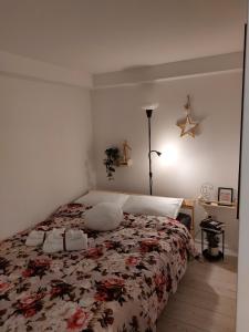 1 Schlafzimmer mit einem Bett mit Blumenbettdecke in der Unterkunft Bowler Hat Apartment Belgrade in Zvezdara