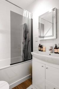 baño blanco con ducha y lavamanos en Marylebone central apartment, en Londres