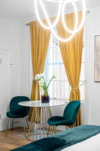 comedor con mesa y 2 sillas verdes en Marylebone central apartment, en Londres