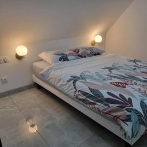 AndolsheimにあるLes Hirondellesのベッドルーム1室(ベッド1台、壁に照明2つ付)