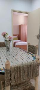 Pokój ze stołem z wazonem kwiatów w obiekcie Essaouira Cool apartments w mieście As-Suwajra