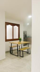 a wooden table and benches in a room at OCASSO JARDIN APARTAMENTO TURPIAL in Jardin