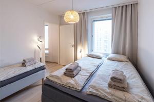 a bedroom with a large bed with towels on it at Stylish Scandinavian Suite - Sauna, Harbor & Free Parking in Helsinki