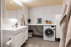 a bathroom with a sink and a washing machine at Stylish Scandinavian Suite - Sauna, Harbor & Free Parking in Helsinki