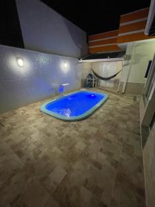 Casa com piscina em condomínio في كاشويرا باوليستا: حوض استحمام أزرق كبير في الغرفة