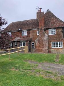 an old brick house with a yard in front of it at Spacious character cottage overlooking fields in Harrietsham