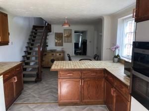 a kitchen with a counter top and a staircase at Spacious character cottage overlooking fields in Harrietsham