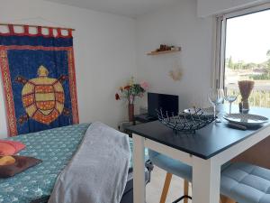 a bedroom with a table and a bed and a desk with a table at Studio Golf Riviera - Axelle Loc'Appart in Mandelieu-la-Napoule