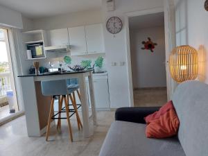 uma sala de estar com uma cozinha com um balcão e uma bancada em Studio Golf Riviera - Axelle Loc'Appart em Mandelieu-la-Napoule