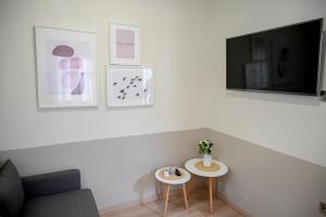 a living room with two tables and a tv at ΜΕΛΑΝΘΙΑ m5 in Preveza