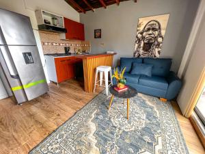 sala de estar con sofá azul y cocina en LA TERRAZA del POBLADO 474-TR1, en Medellín