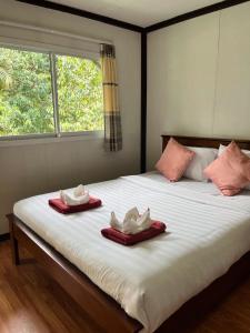 1 dormitorio con 1 cama con 2 toallas y una ventana en Khaosok River Camp, en Khao Sok