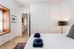 1 dormitorio con 1 cama blanca y 2 toallas azules en ‘The Loft’ – Unley Park Serenity, en Unley