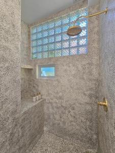 a bathroom with a shower with a glass window at Villa Endless - Two Bedroom Family Suite - Beachfront Luxury - Bingin Beach in Uluwatu