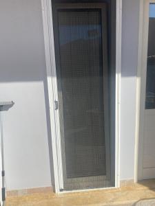 una porta con schermo a maglie sul lato di una casa di New Unique Apartment in Heraklion a Heraklion