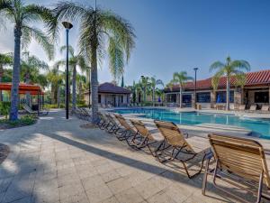 a row of chairs sitting next to a swimming pool at NEW! Luxury Solterra Resort Home, Disney World Family Retreat Vacation in Davenport