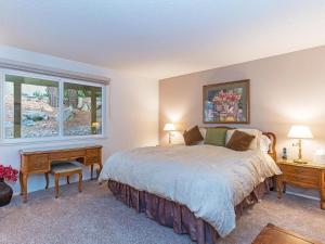 um quarto com uma cama e duas mesas e uma janela em 51 Mountain Shadows - 2 bedroom condo with pool em Incline Village