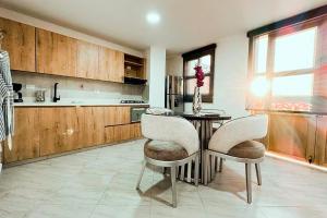 cocina con mesa, 2 sillas y barra en Apartamento 307 - Vista a la Represa - 1 Habitación y Sofa Cama - Rentas Cortas Gerencial, en Guatapé