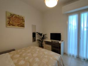 a bedroom with a bed and a desk with a television at Casa Ewa - Centro Pesaro in Pesaro