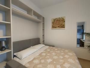 a bedroom with a bed in a room with shelves at Casa Ewa - Centro Pesaro in Pesaro