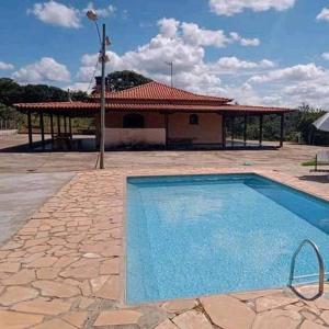 a large swimming pool in front of a house at Sítio morada nova in Contagem