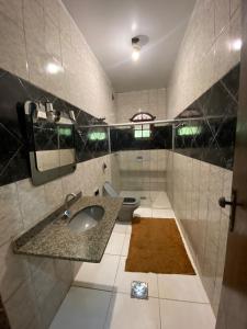 uma casa de banho com um lavatório e um WC em Sítio morada nova em Contagem
