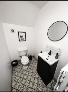 a bathroom with a toilet and a sink and a mirror at The White Hart in Kings Lynn