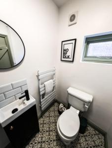 a bathroom with a toilet and a sink and a mirror at The White Hart in Kings Lynn